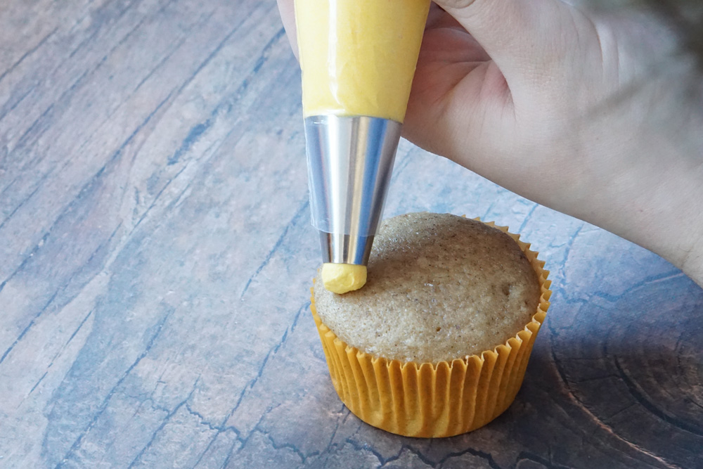 Piping frosting onto the cupcake