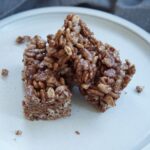 A chocolate rice krispies treat broken in half.