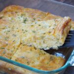 Cutting a slice of green chili casserole