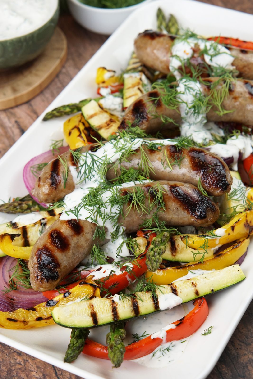 Grilled brats and veggies with dill sauce