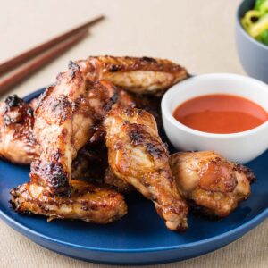 orange chicken wings with dipping sauce.