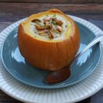 Pumpkin soup in a pumpkin with pumpkin seeds on top
