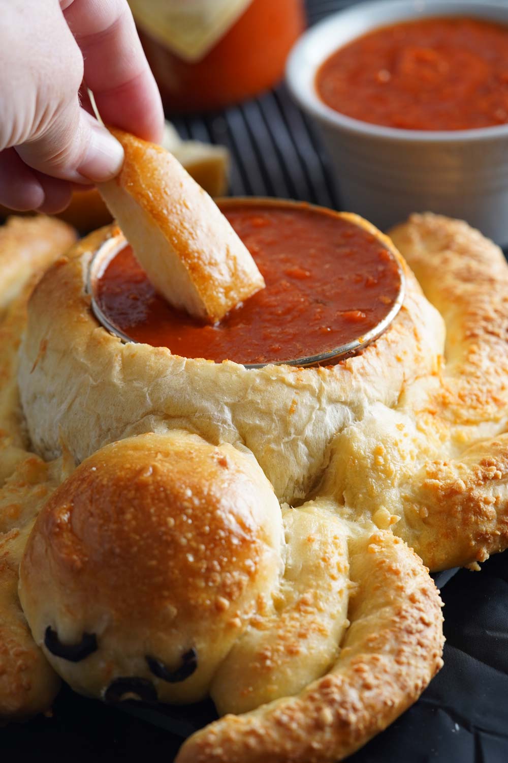 Dipping a breadstick into the Spider breadstick bowl for Halloween