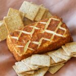 A block of smoked cream cheese with crackers