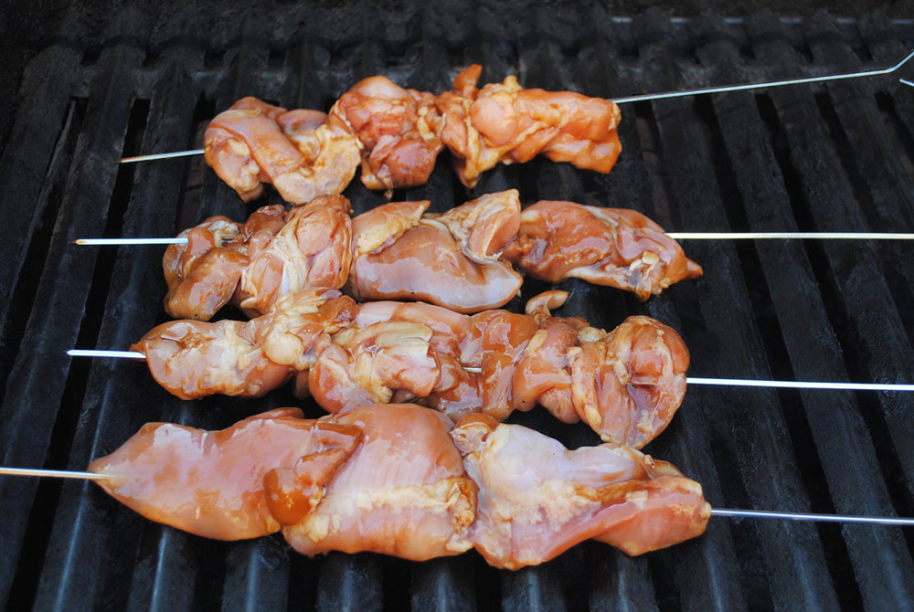 skewered chicken thighs on a grill
